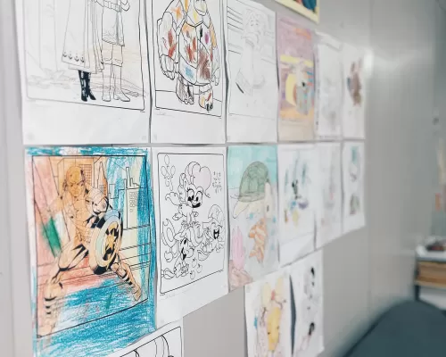 a wall filled with childrens drawings