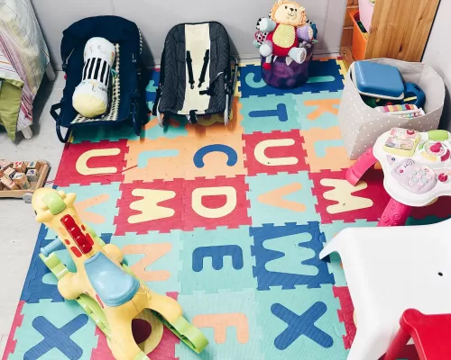 a room filled with toys and a mat with alphabetical letters on it